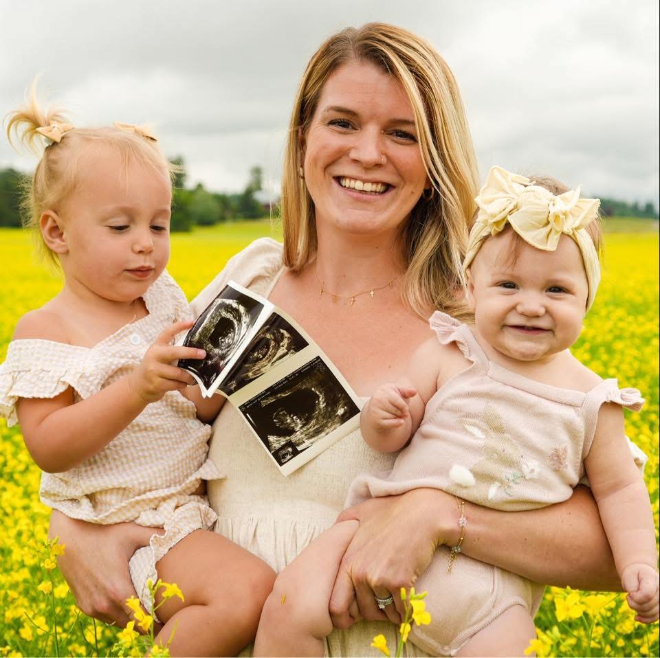Trinity Wahl with her children in a field of wildflowers